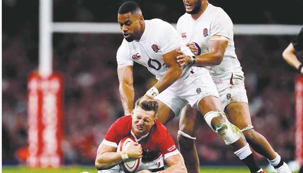 Walesu2019 Dan Biggar (bottom) in action with Englandu2019s Joe Cokanasiga (centre) during their World Cup warm-up match in Cardiff yesterday. (Reuters)