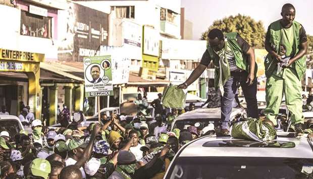 Danny Yenga, a parliamentary candidate for the ruling Patriotic Front of the incumbent President Edgar Lungu throws a pagne printed with the picture of the president Lungu during a campaign parade in Lusaka, on Tuesday.