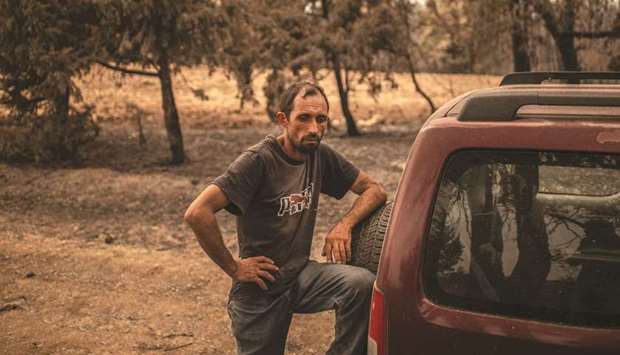 Kostis Angelou shepherd, who lost a herd of 372 animals, stands next to his car in a forest following a wildfire near Kerasia Village on Evia (Euboea) island yesterday. (AFP)