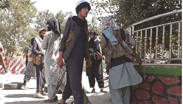 Taliban fighters stand along the roadside in Ghazni yesterday, as they move closer to Kabul after taking Ghazni city.