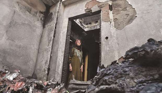 An Algerian woman inspects the damages at her home due to forest fires in the Ait Daoud area.