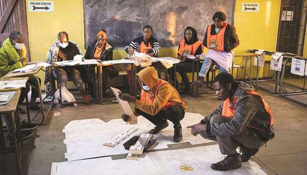 Staff from the Electoral Commission of Zambia count ballot papers at a polling station in Lusaka yesterday.