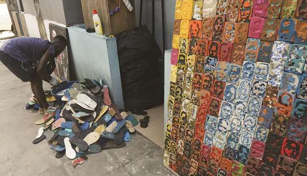 Ivorian painter Aristide Kouame washes used flip-flops at his workshop in Abidjan.