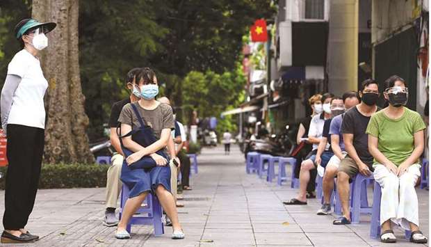 Residents wait to provide swab samples for Covid-19 testing along a street in Hanoi yesterday, amidst the government imposed two-week lockdown to stop the spread of the coronavirus.