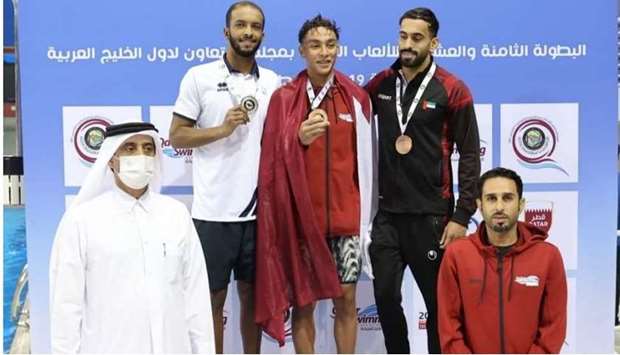 Qatar Swimming Association President Khaleel al-Jabir (left) crowns the winners of the menu2019s 18 and over 200m medley, which was topped by Qataru2019s Mohamed Mahmoud (centre) on Saturday.