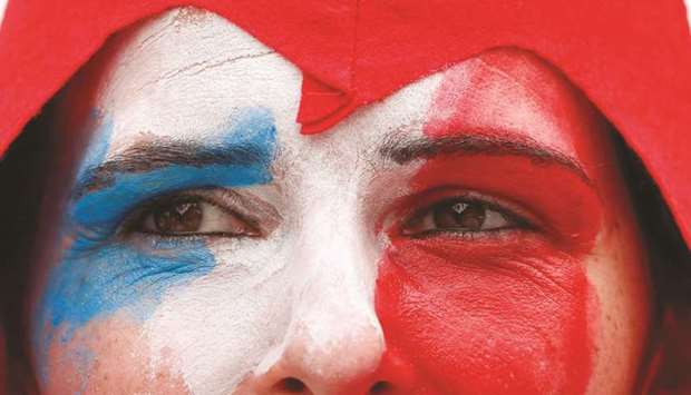 A protester with the face painted in French colours during a demonstration against the restrictions, including a compulsory health pass, in Paris, yesterday. (Reuters)