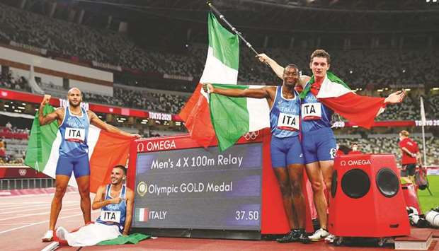 Italyu2019s Lorenzo Patta, Lamont Marcell Jacobs, Eseosa Desalu and Filippo Tortu celebrate after winning the menu2019s 4x100m relay final at the Olympic Stadium during the Tokyo Olympic Games yesterday. (Reuters)