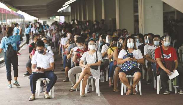 Residents wait for vaccination in Marikina City, suburban Manila, yesterday.