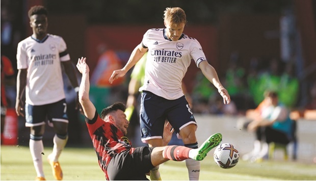 Arsenalu2019s Martin Odegaard (right) vies for the ball with Bournemouthu2019s Kieffer Moore during the Premier League match at the Vitality Stadium in Bournemouth, Britain, yesterday. (Reuters)