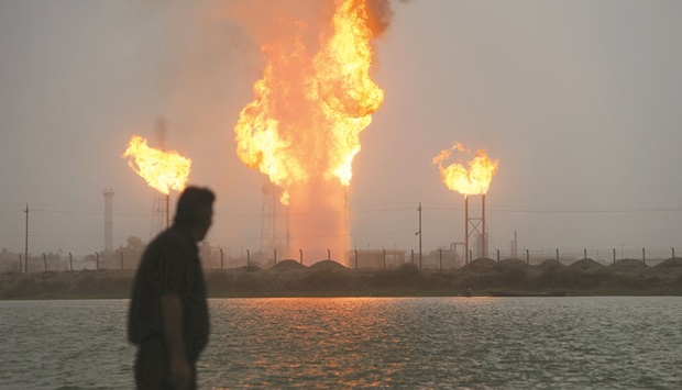 A man looks at flames rising from oil refinery pipes in Basra (file). Beijing has become one of the largest importers of Iraqi crude, and in 2021 accounted for 44% of Iraqu2019s oil exports, according to prime ministerial adviser Muzhar Saleh.