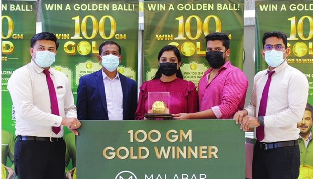 One of the 10 lucky winners of Malabar Gold & Diamonds' u2018Win 10 Golden Balls campaignu2019, Thulasi Haridas and family, receiving the 100gram Golden Ball from Raju T Johny, deputy branch head, Malabar Gold & Diamonds, in the presence of team members at the outlet in Al Watan Center, Doha.