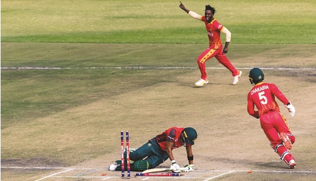 Bangladesh batsman Anamul Haque Bijoy lies on the pitch after loosing his wicket as Zimbabwe wicket keeper Regis Chakabva and bowler Wessly Madhevere celebrate during the third and final T20 international at the Harare Sports Club. (AFP)