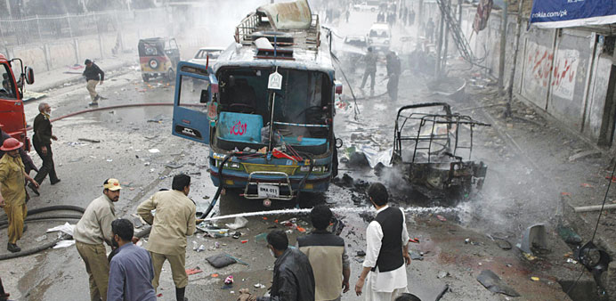 Firefighters extinguishing a fire on burning vehicles at the site of a bomb attack in Quetta yesterday.