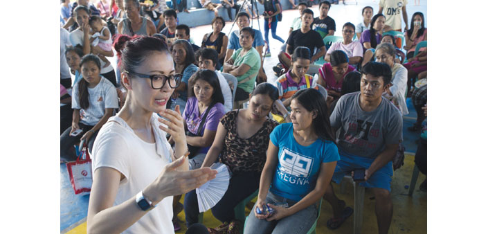 Barbara Ang (left), a daughter of one of the owners of Kentex, the footwear factory gutted by fire that killed 72 people, talks to the relatives of th