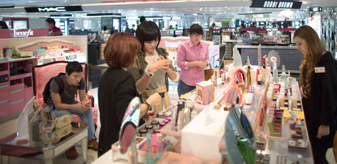 Customers browse cosmetics inside a LVMH shop in Hong Kong. The worldu2019s biggest luxury group said yesterday it plans to slow annual China expansion to