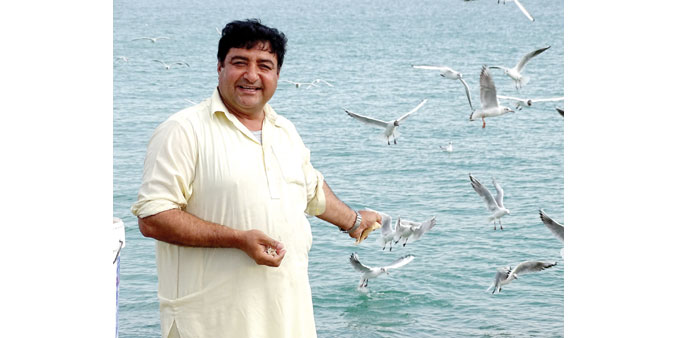 HAPPY: Javed Khan feeding the birds along the Corniche.