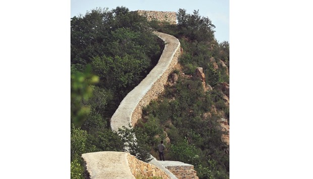 This picture taken on September 21 shows a villager standing on a paved-over section of the Great Wall of China at Suizhong, in Chinau2019s northeast Liaoning province.