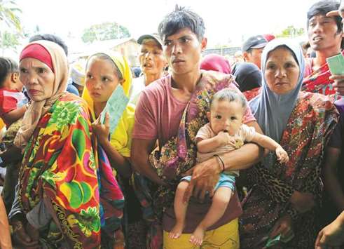 Evacuees wait for their names to be called to get relief goods, after fleeing to an evacuation centre to avoid the fighting in Marawi between the government troops and Islamic State-linked militants, in Saguiaran town, Lanao Del Sur, southern Philippines yesterday.