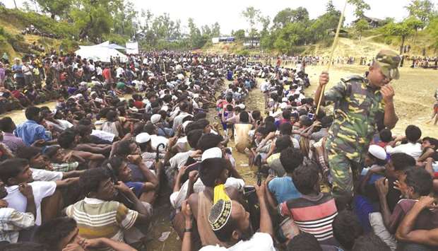 Rohingya refugees wait as food is distributed by the Bangladeshi army at Balukhali refugee camp near Gumdhum yesterday.