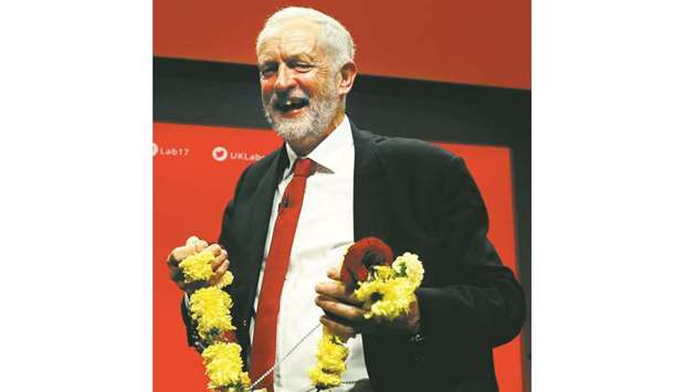 Labour leader Jeremy Corbyn holds a garland after delivering his keynote speech at the Labour Party Conference in Brighton yesterday.
