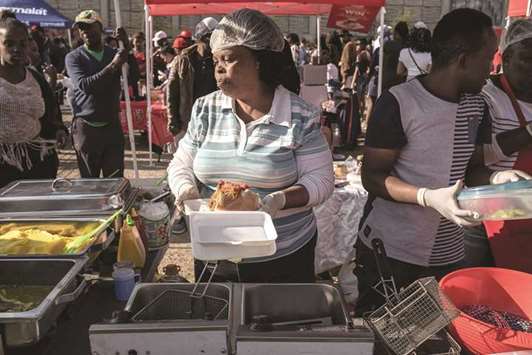 A street vendor prepares a u2018Kotau2019 sandwich during the Kota Festival at Kliptown in Soweto.