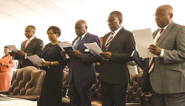 Ministers take their oath of office during the swearing in ceremony for Zimbabweu2019s new cabinet ministers at State House in Harare yesterday.