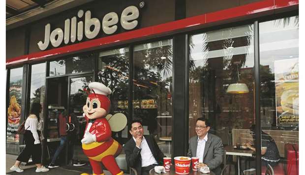 Ernesto Tanmantiong (right), president and CEO of Jollibee Foods Corp, and CFO Ysmael Baysa, pose for a picture outside a Jollibee branch in Pasig City, Metro Manila. Jollibee, which is valued at $4.8bn and has 16 brands or franchises to its name, aims to have six brands each in the US and China, just as it does in the Philippines.