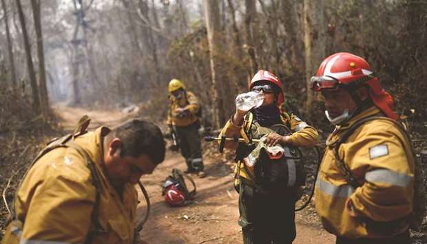 A firefighter of Argentinau2019s army drinks water as she works to control a fire near Santa Monica community in Concepcion, Bolivia, yesterday.