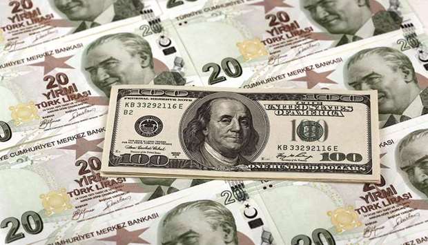 A file photo illustration in Istanbul shows a 100 US dollar banknote against 20 Turkish lira banknotes. Societe Generale on Monday said the lira would likely weaken to 8.85 by year end, adding the central bank increasingly risks making the mistake of cutting interest rates too early.