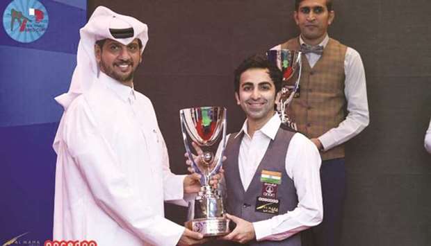 IBSF President Mubarak al-Khayarin (left) presents the 6-Red World Cup to champion Pankaj Advani of India as runner-up Babar Masih (right) of Pakistan looks on.