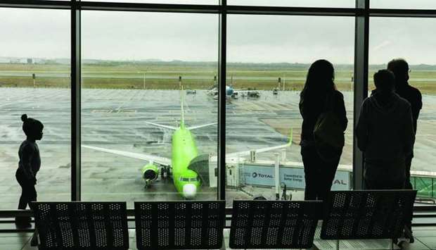 Travellers look out from a gate towards a passenger aircraft on the tarmac at Cape Town International Airport in Cape Town, South Africa (file). Only a few airlines in Africa like Ethiopian Airlines, South African Airways, EgyptAir and Royal Air Maroc ensure a significant connectivity with the rest of the world.