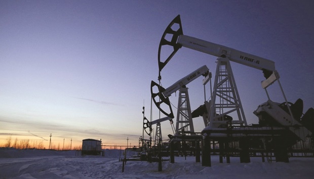 Pump jacks are seen at the Lukoil company owned Imilorskoye oil field, as the sun sets, outside the West Siberian city of Kogalym, Russia. The country exports roughly 8mn barrels of crude and fuel per day, making it the largest oil exporter in the world.