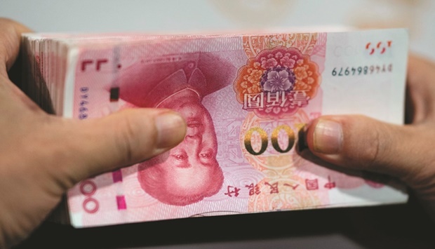 An employee counts out 100 yuan notes at a bank in Shanghai (file). Chinau2019s credit growth recovered in August from a record low after the central bank cut rates and pushed banks to lend more, although still anaemic household borrowing and the return of shadow banking suggest that real demand for loans is still not strong.
