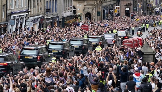 Crowds watch the cortege carrying the coffin of Queen Elizabeth arrive in Edinburgh, Scotland, Britain, yesterday.
