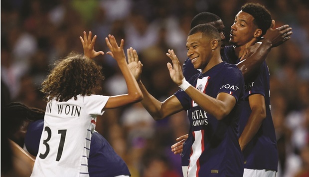 A pitch invader celebrates with Paris St Germainu2019s Kylian Mbappe (centre) during the Ligue 1 match on Wednesday. (Reuters)