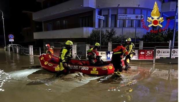 Rescue workers rescue people on a dinghy boat on a flooded street after heavy rains hit the east coast of Marche region in Senigallia, Italy. Vigili del Fuoco/Handout via REUTERS