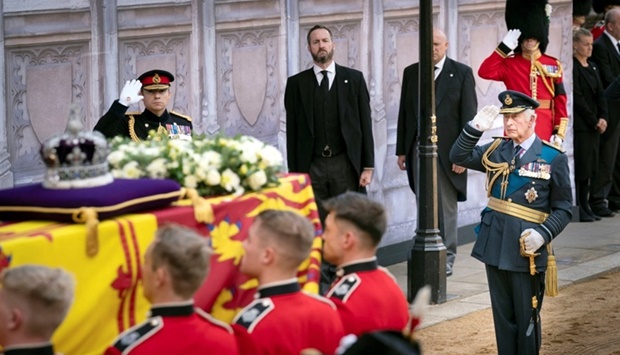 King Charles III, salutes as the bearer party carry the coffin of his mother, Queen Elizabeth II, into Westminster Hall, London, on September 14, where it will lie in state ahead of her funeral on Monday. Danny Lawson/Pool via REUTERS