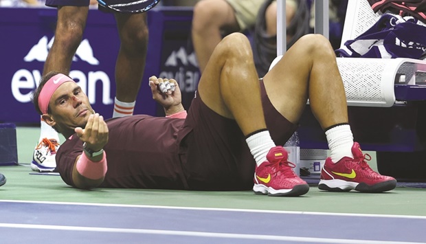 Rafael Nadal of Spain lies on the ground after accidentally hitting himself in the head with his racket against Fabio Fognini of Italy during their singles match on Day Four of the 2022 US Open in New York. (AFP)