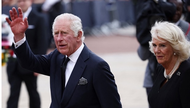 Britain's King Charles waves as he walks with Queen Camilla outside Buckingham Palace, following the passing of Britain's Queen Elizabeth, in London. REUTERS