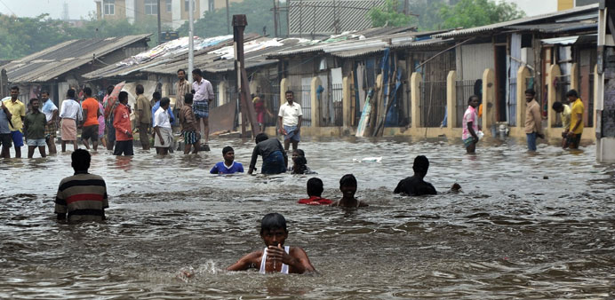 Locals wade through a waterlogged street in Chennai yesterday.