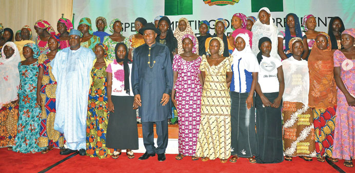 President Jonathan and senate president Mark with some of the school girls who escaped from the Boko Haram in Abuja yesterday.