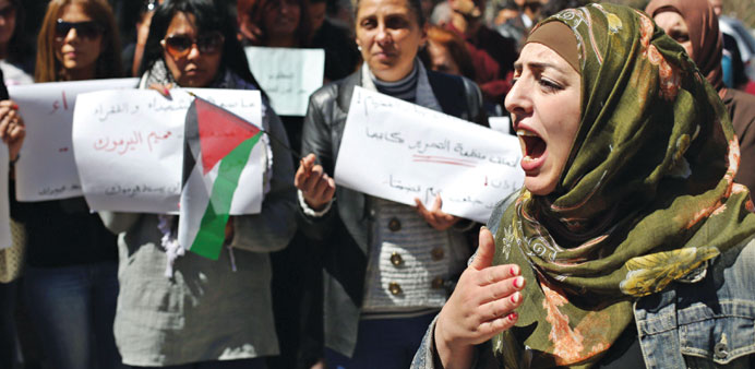 Protesters shout slogans and hold banners during a demonstration in solidarity with the Palestinians living in Syriau2019s Yarmuk camp, outside the PLO he