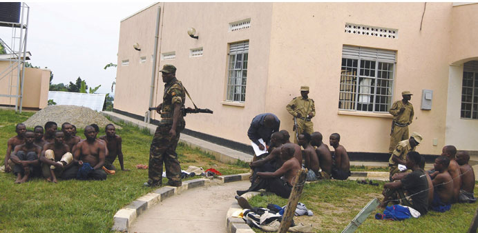 Ugandan soldiers detain men suspected to be militia members after gunmen attacked Bundibugyo town.