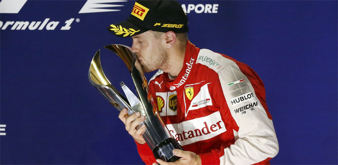 Lewis Hamilton kisses his trophy on the podium