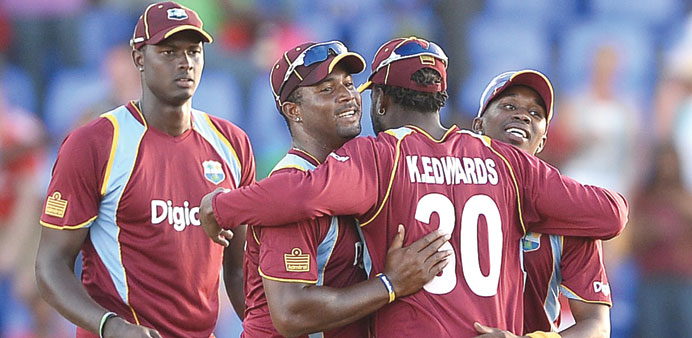 West Indies captain Dwayne Bravo (right) celebrates with teammates after beating England in the first One Day International at the Sir Vivian Richard 