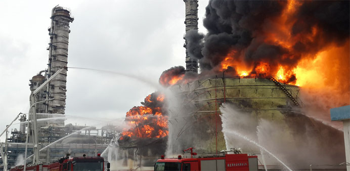 Firefighters battle a blaze following an explosion at a plant producing paraxylene