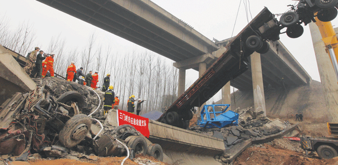 A damaged truck (right) is moved by rescuers at the scene of the collapsed Yichang bridge near the city of Sanmenxia, central Chinau2019s Henan province y