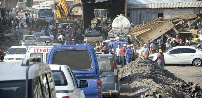 Members of search and rescue teams, government officials and miners are seen around the site of the collapsed coal mine.