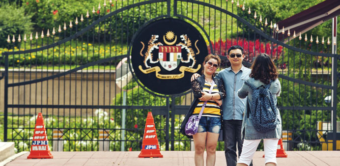 Tourists pose for photographs in front of the Malaysian Prime Ministeru2019s office in Putrajaya.