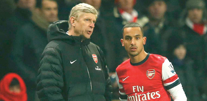 Arsenal manager Arsene Wenger (L) speaks with Theo Walcott during their English Premier League match against West Ham on Wednesday.